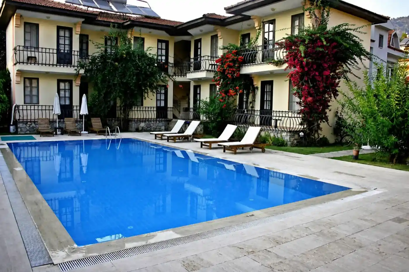 Göcek'teki Görkem Apart Otel'in havuzu ve çiçeklerle kaplı cephesi